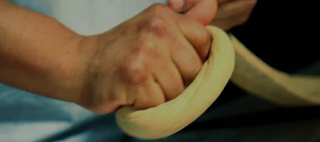 hand rolling a bagel