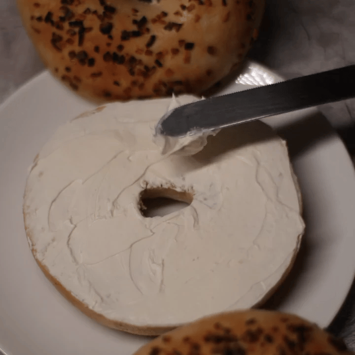 onion bagel with cream cheese and honey