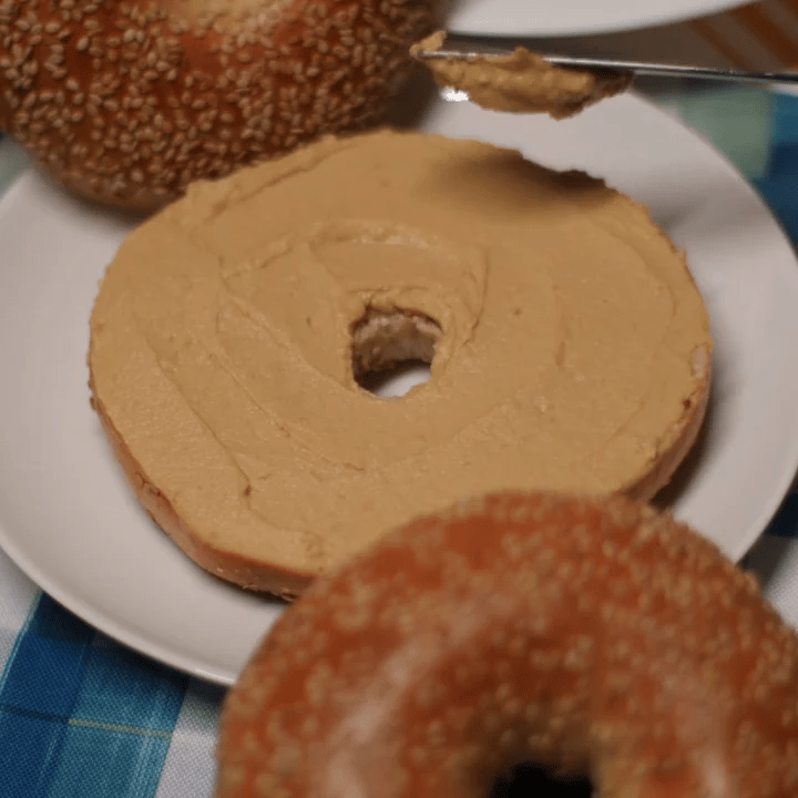 sesame bagel with peanut butter and sesame seeds